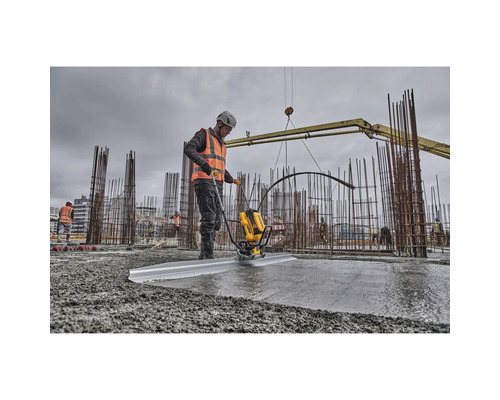 Ein Bauarbeiter verwendet eine Betonabziehmaschine auf einer Baustelle, um Beton zu glätten.