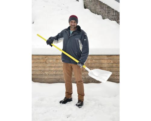 Mann mit Schneeschaufel im Winter