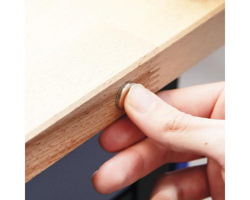 Hand befestigt Magnetverschluss an einem Holzbrett