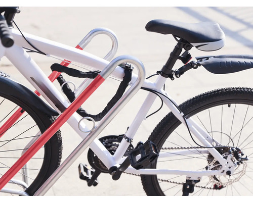 Fahrräder stehen an einem Fahrradständer mit Kettenschloss