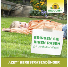 Mädchen liegt auf Rasen mit Schild: Bringen Sie Ihren Rasen gut durch den Winter. Azet Herbstrasendünger