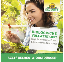 Frau im Garten mit Erdbeeren und Neudorff Logo, die AZET Beeren- und Obstdünger verwendet