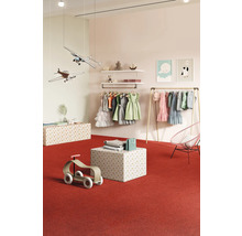 Kinderbekleidungsgeschäft mit Kleidern, Spielzeugflugzeugen und Holzspielzeug auf rotem Teppich.