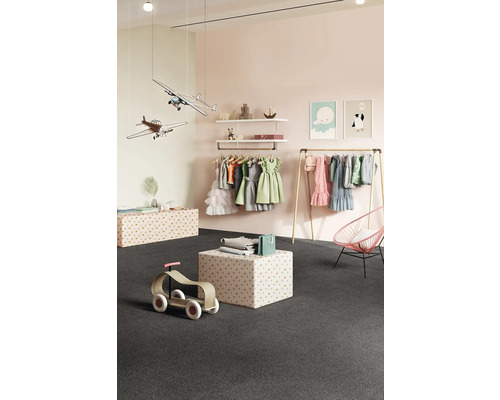 Kinderzimmer mit Kleiderständer, Regalen und Spielzeug auf dunklem Teppichboden