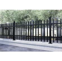 Metallzaun auf einer Betonmauer, mit Bäumen im Hintergrund