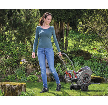 Frau benutzt Einhell Schlauchbox im Garten für die Gartenarbeit.