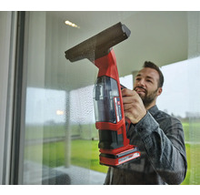 Mann reinigt Fenster mit einem Akku-Fenstersauger von Einhell