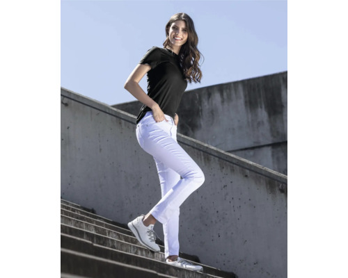 Frau mit schwarzem T-Shirt, weißen Jeans und Sportschuhen auf einer Treppe