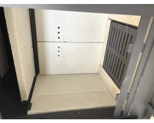 Innenraum eines Kamins mit Feuerraumauskleidung und Zuluftklappe