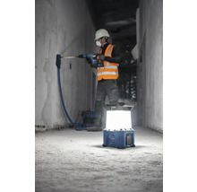 "Bauarbeiter bohrt mit Bohrhammer in Wand