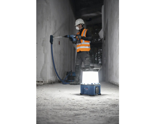 "Bauarbeiter bohrt mit Bohrhammer in Wand