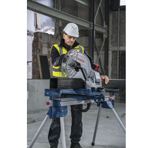 Ein Arbeiter in Arbeitskleidung verwendet eine Metallkreissäge von Bosch, um ein Metallrohr zu schneiden.