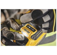 Gelbe Arbeitsleuchte in der Hand mit Handschuhen