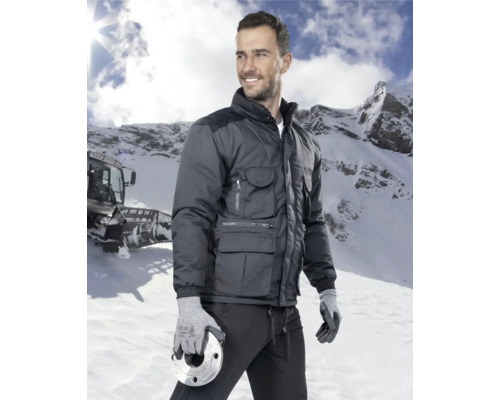 Mann in Arbeitsjacke und Handschuhen im Schnee