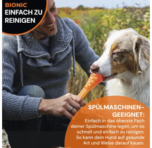 Mann gibt Hund einen Bionic Kaustab zum Kauen