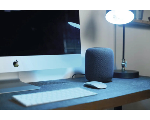 Szene mit einem Computer, einer Tastatur, einer Maus und einem Lautsprecher auf einem Schreibtisch