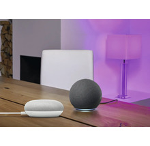 Zwei Lautsprecher auf einem Tisch, im Hintergrund ein Stuhl und eine Lampe