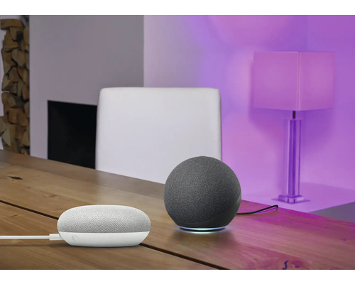 Zwei Lautsprecher auf einem Tisch, im Hintergrund ein Stuhl und eine Lampe