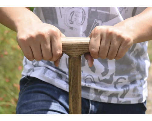 Nahaufnahme einer Person, die einen Spatenstiel mit Holzgriff hält