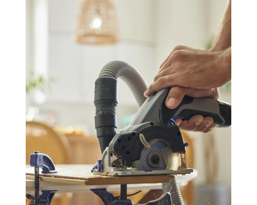 Mann sägt Holz mit einer Tauchsäge mit Staubabsaugung