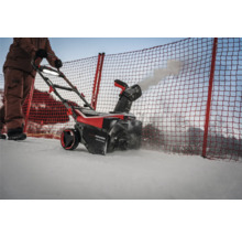 Eine Person bedient eine Schneefräse zum Schneeräumen.