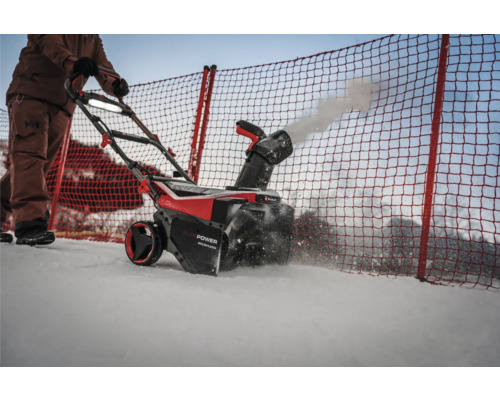 Eine Person bedient eine Schneefräse zum Schneeräumen.