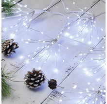 Lichterkette mit LED-Sternen und Tannenzapfen auf einem Holztisch