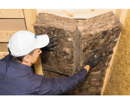 Eine Person, die Mineralwolle zur Wärmeisolierung anbringt.