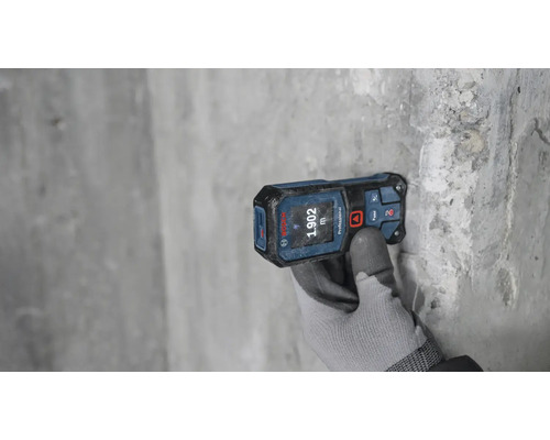 Laser-Entfernungsmesser bei Messung an grauer Wand