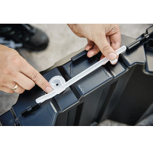 Eine Person befestigt eine Dichtung an einer Aufbewahrungsbox aus Kunststoff.