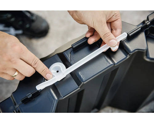 Eine Person befestigt eine Dichtung an einer Aufbewahrungsbox aus Kunststoff.