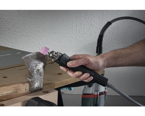 Person schärft Axt mit biegsamer Welle und Schleifaufsatz