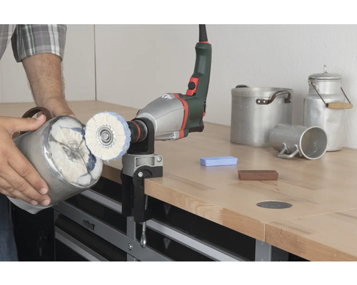 Poliermaschine mit Polieraufsatz an Werkbank befestigt beim Polieren eines Metallobjekts.