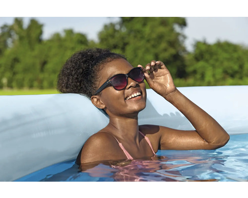 Frau mit Sonnenbrille im aufblasbaren Pool