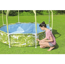 Aufbau eines runden Stahlrahmenpools mit Blätterdesign und Sonnendach im Garten.