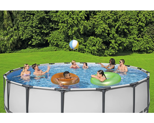 Familie und Freunde genießen einen Frame Pool im Garten mit einem Ball