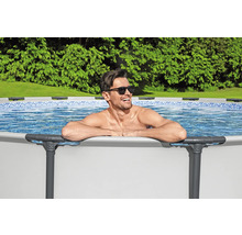 Mann entspannt im Stahlrahmenpool im Garten