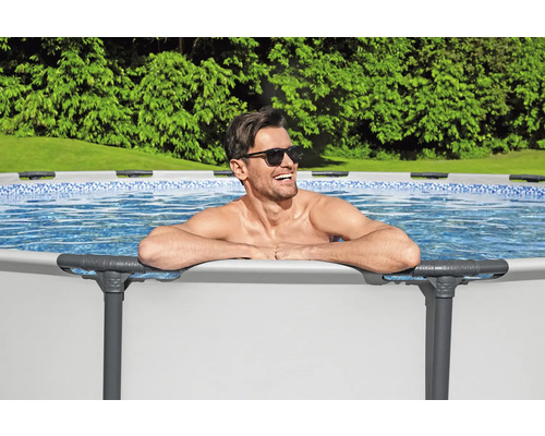 Mann entspannt im Stahlrahmenpool im Garten