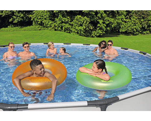 Szene mit einem Pool und mehreren Personen, die sich im Wasser vergnügen und Schwimmringe nutzen