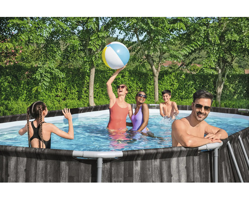 Familie hat Spaß in einem Pool mit Holzverkleidung im Garten.