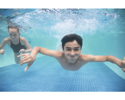Unterwasseraufnahme von zwei Kindern in einem Schwimmbecken