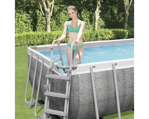 Rechteckiger Swimmingpool mit Leiter im Garten und Frau im Bikini