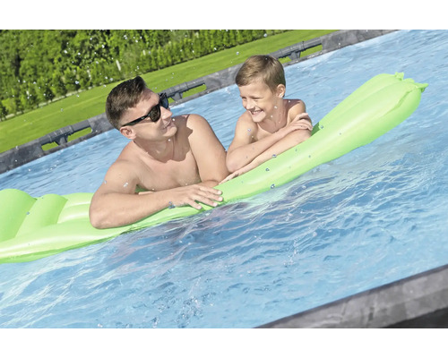 Vater und Sohn entspannen auf einer aufblasbaren Wassermatratze im Pool.