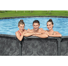 Familie entspannt sich in einem Frame-Pool im Garten.