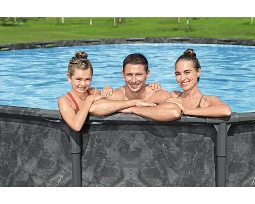 Familie entspannt sich in einem Frame-Pool im Garten.