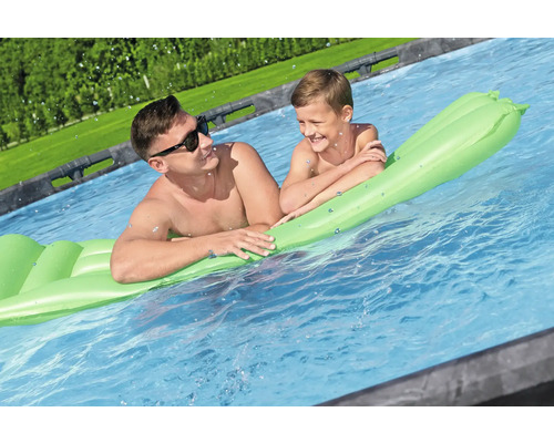 Vater und Sohn entspannen auf einer Luftmatratze im Pool