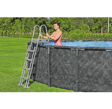 Frau steigt mit einer Leiter in einen Frame-Pool