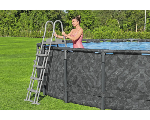 Frau steigt mit einer Leiter in einen Frame-Pool