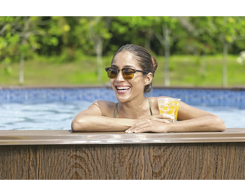 Frau im Pool mit einem Getränk in der Hand