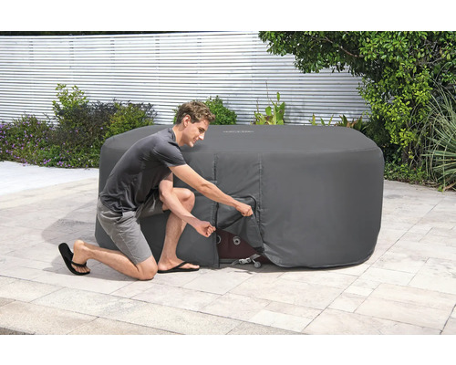 Abdeckung für einen Whirlpool im Garten mit einer Person, die die Abdeckung anhebt.